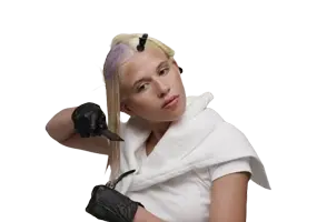 Stylist spreading toner evenly from roots to tips on blonde hair